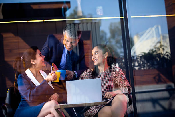 istock Happy business people drinking coffee and using laptop 1462957007