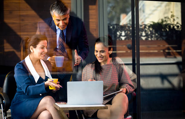 istock Happy business people drinking coffee and using laptop 1462957039
