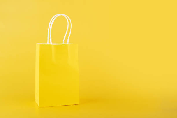 shopping bag on yellow background, copy space, monochrome,one color stock photo