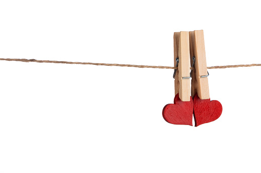 Clothes pegs and two red hearts on rope isolated on white background Valentines day concept