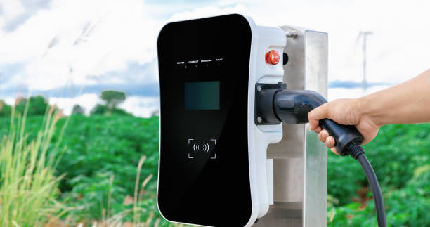 istock Hand insert connector plug to EV with progressive natural scenic and windturbine 1462959344