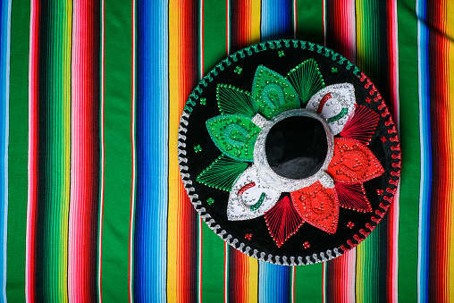 Mariachi hat with the colors of the Mexican flag on a colorful serape. Mexican sombrero.