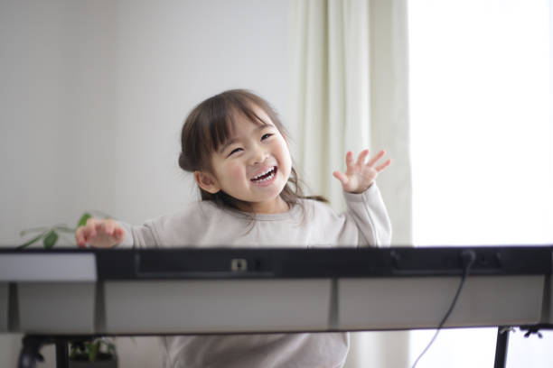 girl practicing piano - toddler music asian ethnicity child imagens e fotografias de stock