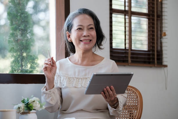 istock Smart asian mature middle-aged businesswoman CEO boss leader teacher using tablet, e-learning, working remotely online in home office 1462962719