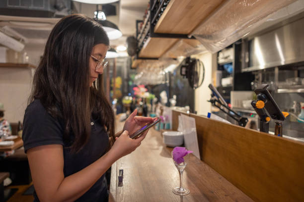 istock Young woman waiting for dinner in restaurant -  using smart phone 1462963099
