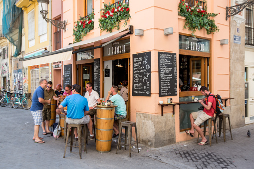 VALENCIA, SPAIN - JUNE 18, 2015: People eat and drink on a street in a corner tasquita  tapas bar in Valencia, Spain.