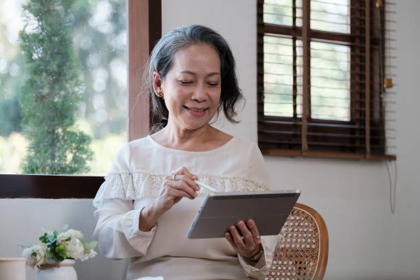 istock Smart asian mature middle-aged businesswoman CEO boss leader teacher using tablet, e-learning, working remotely online in home office 1462963211