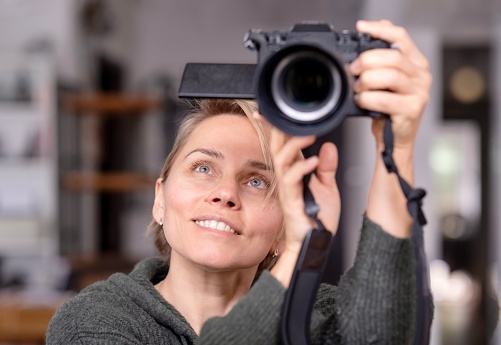 Woman using mirrorless camera at home
