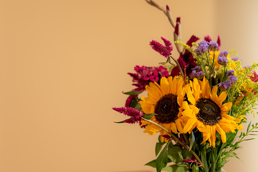 A closeup shot of a flower bouquet in a vase on a yellow background