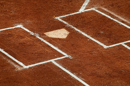 The home of the first base with white chalk lines in a baseball field