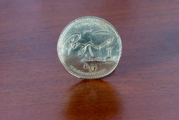 istock Broken coin from one Quetzal, Guatemala, 2001, on wood texture. 1462974328