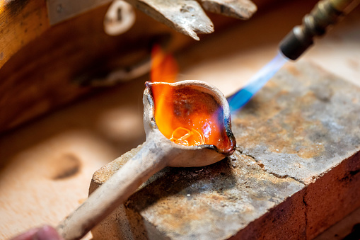 Jewelry artesan working on a melting ring with torch