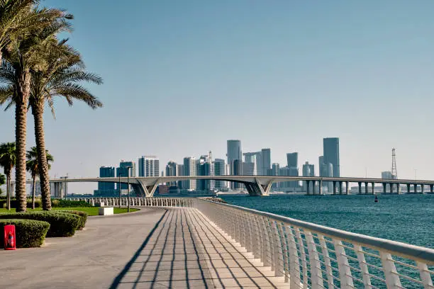 Photo of Empty seafront with the skyline view of Abu Dhabi city with high-rise buildings in the background