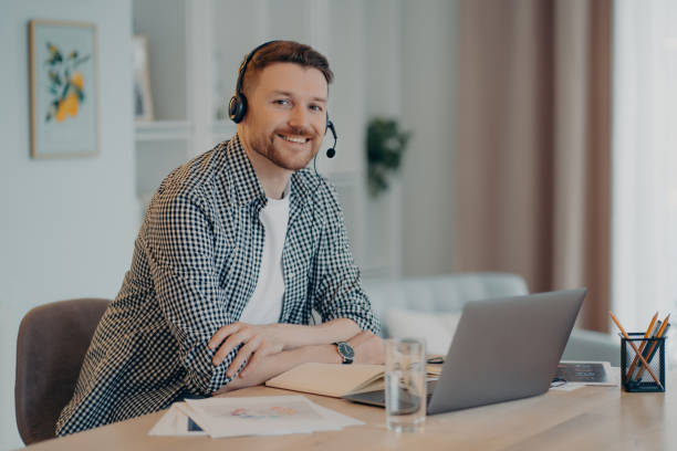 istock Smiling man enjoying remote work at home, looking at camera 1462977124