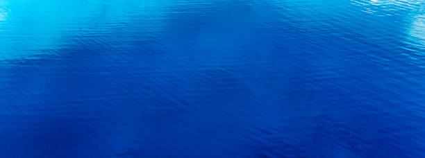 istock Blue water texture, on the surface of a clear blue lake. 1462980695