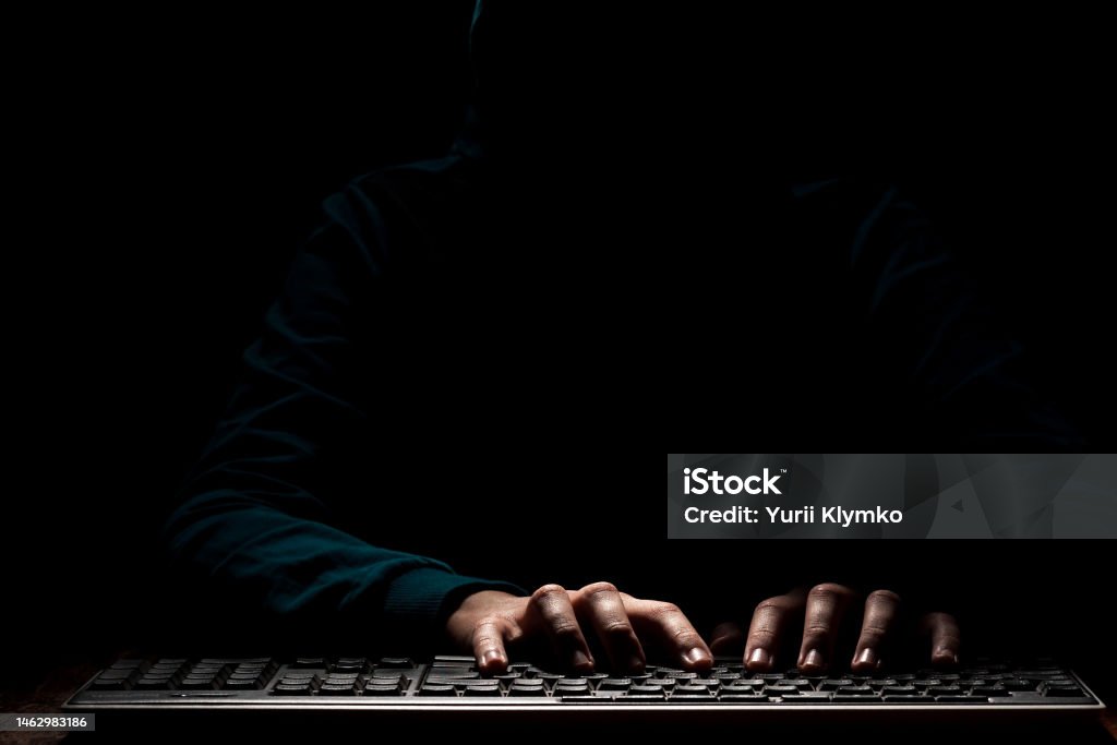 black information technology Unknown person hands using a keyboard sends message with intimidating and threatening to the interlocutor Scammer Stock Photo