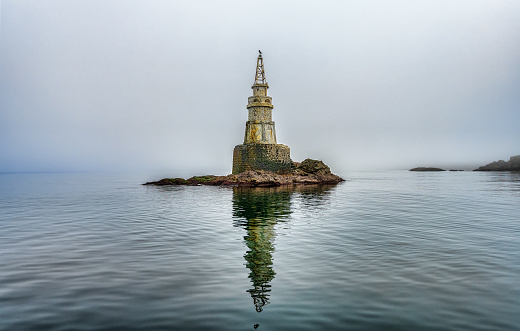 The reflection of an old lighthouse of Ahtopol in Bulgaria on the water