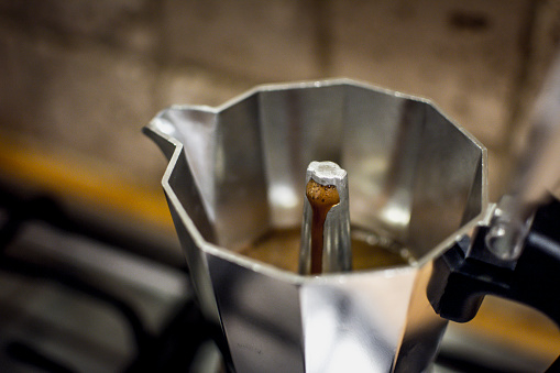 Classic Stovetop or Moka Pot Espresso Maker brewing coffee. Close-up and selective focus.