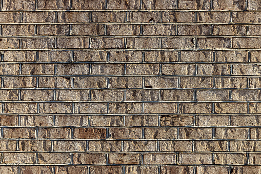 A shot of a brown brick wall of a building in bright sunlight in Georgetown, United States