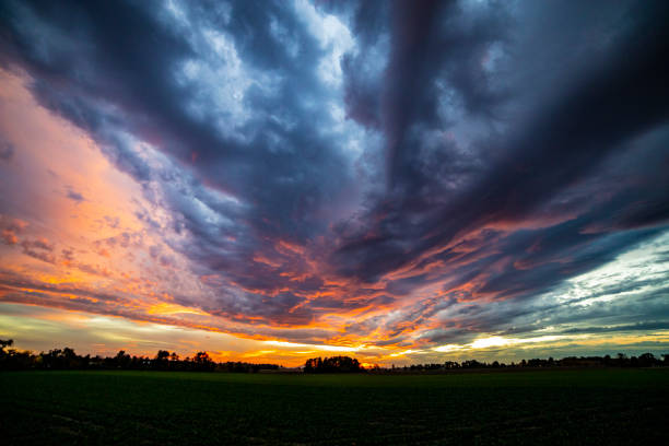 istock Dramatic view of dark clouds flowing over a green field in the evening 1462995349