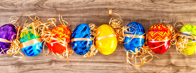 A top view of colorful Easter eggs on the wooden table