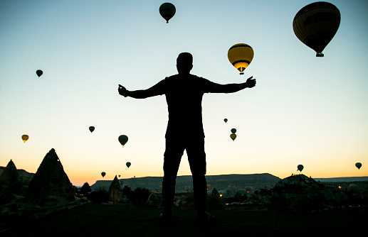 Silhouette of man with open arms towards the sky in Cappadocia