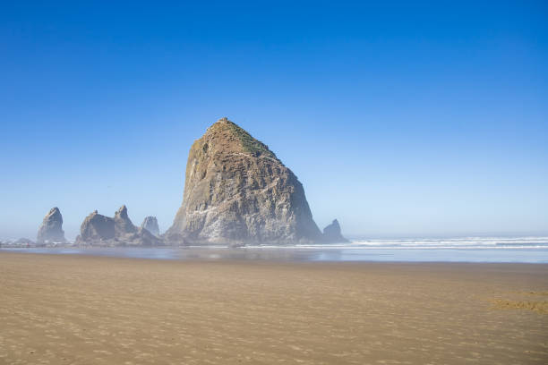 istock Big rock in the water under a clear sky on the beach 1462998385