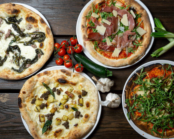 istock Top view of various pizzas on a wooden surface 1463000914