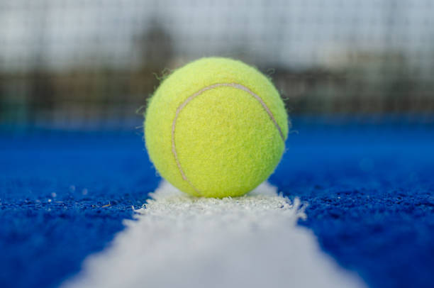 選択フォーカス。青いパドルテニスコートのライン上のボールの地上ビュー - indoor tennis ストックフォトと画像