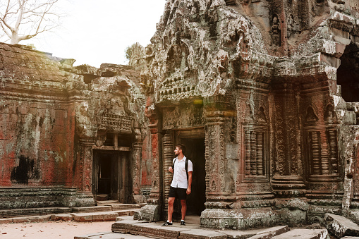 A man exploring the temples at the Angkor Wat, Ta prohm complex