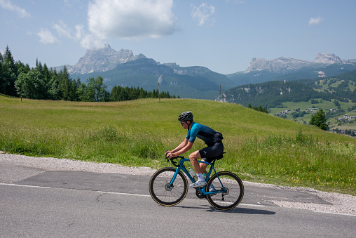 Veneto, Italy - June 27, 2022: Cyclist circulating on a road in Cortina d'Ampezzo, Province of Belluno