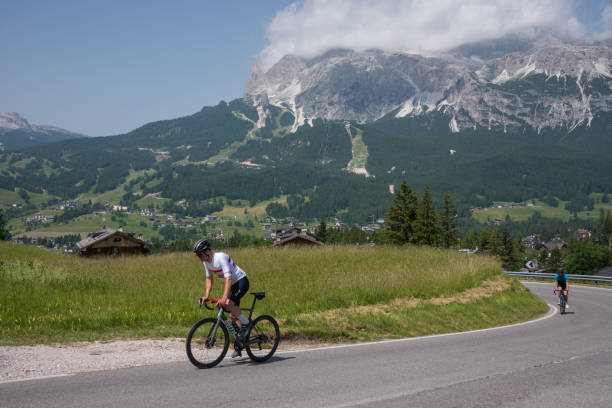 cyclists ascending a road - beauty in nature belluno clear sky color image imagens e fotografias de stock