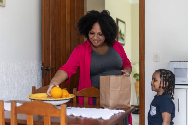 istock Pregnant woman cutting oranges with son 1463045602