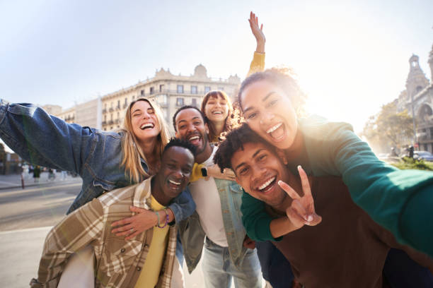 A group of cheerful students college friends taking a selfie as they travel through European cities. A group of cheerful students college friends having fun together as they travel through European cities. Happy community of diverse people. Selective focus on the smily couple taking the selfie. selfie madrid photos stock pictures, royalty-free photos & images
