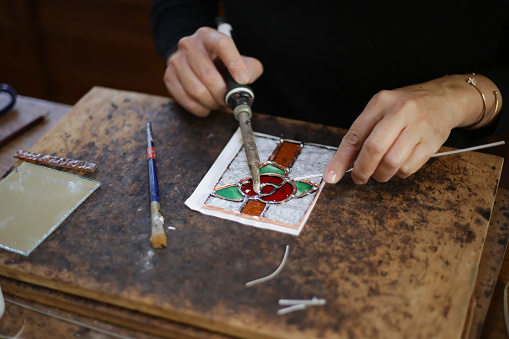 A woman making a stained glass work