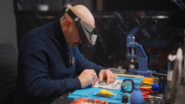 horloger réparant une montre sur son lieu de travail - male magnifying glass caucasian technician photos et images de collection