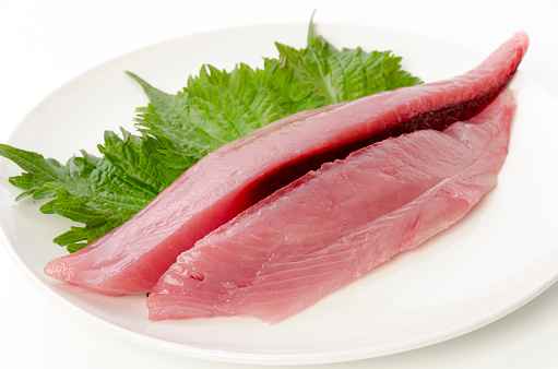 Yellowfin tuna fillet on plate on white background