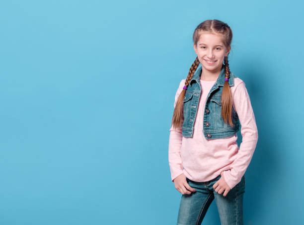 istock Teenage girl in confident pose over blue background 1463055836