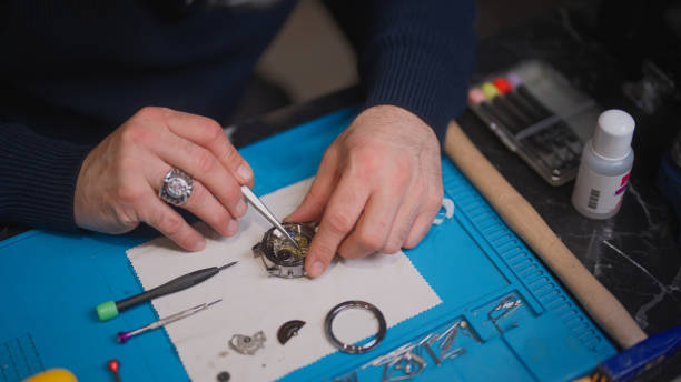 zbliżenie zegarmistrza naprawiającego zegarek w swoim miejscu pracy - male magnifying glass caucasian technician zdjęcia i obrazy z banku zdjęć
