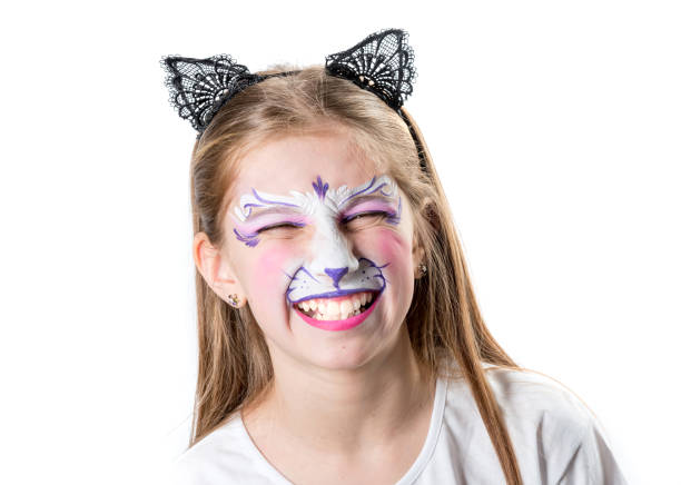 Cheerful girl with face painting of a tiger with cat ears headband isolated on a white background