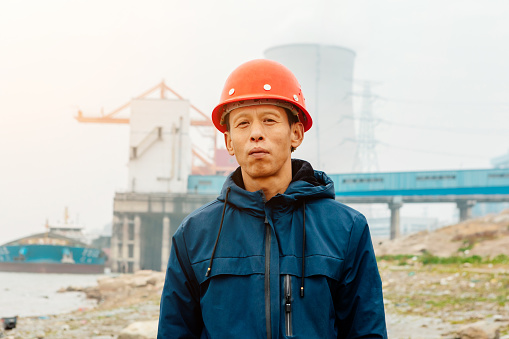 Portrait of an engineer standing in front of an outdoor dock power plant