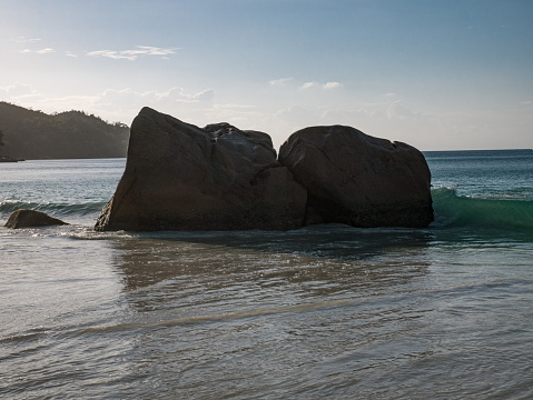 Fascinating waves and boulders on the beach Anse Lazio of the Seychelles.