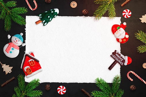 Blank paper surrounded by Christmas decorations for greeting text