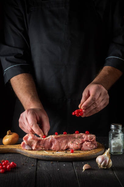 istock In the restaurant kitchen chef prepares raw calf meat. Before baking, the cook puts the viburnum on the beef. National dish 1463064031