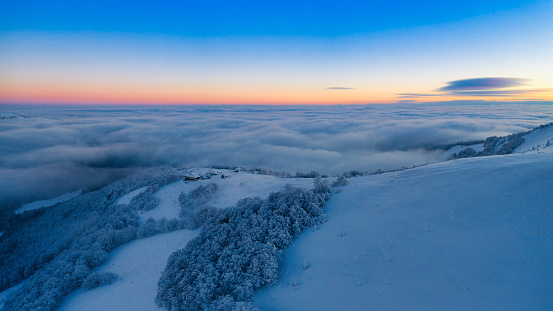 Snow-covered mountain peaks at dawn. View from a drone. Ukrainian Carpathian Mountains. A wonderful dawn in the mountains.