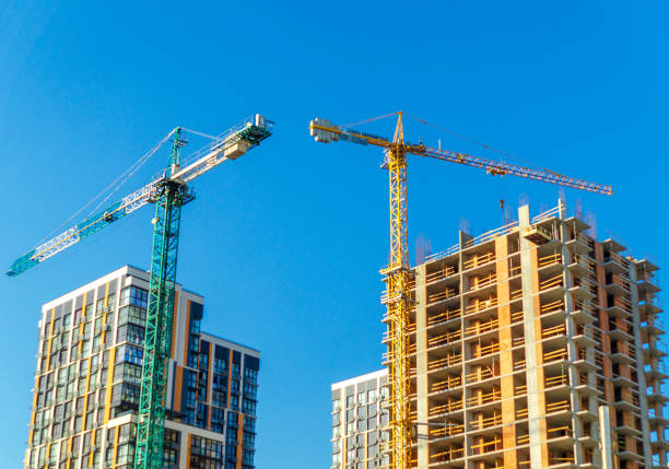 istock Two construction cranes build houses on sky background. 1463065505