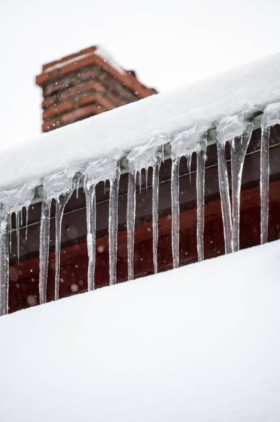 istock Dangerous sharp icicles and snow hanging from the roof. 1463066869