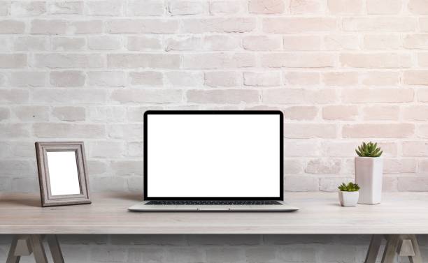 istock Laptop mockup on work desk. Work at home concept. Clean desk with photo frame and plants 1463066962