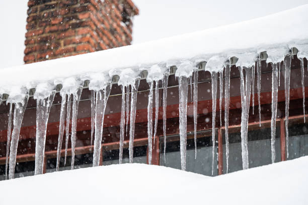 istock Dangerous sharp icicles and snow hanging from the roof. 1463067563