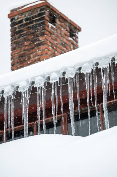 istock Dangerous sharp icicles and snow hanging from the roof. 1463067743